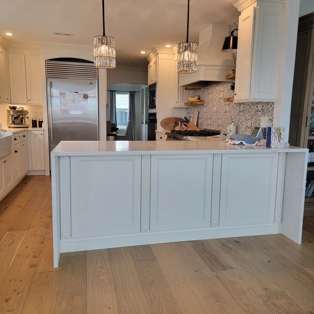 Kitchen work zone with stone counters, sink, and coordinated cabinetry